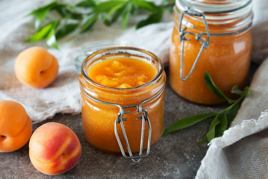 Apricot preserves in a glass jar with fresh apricots