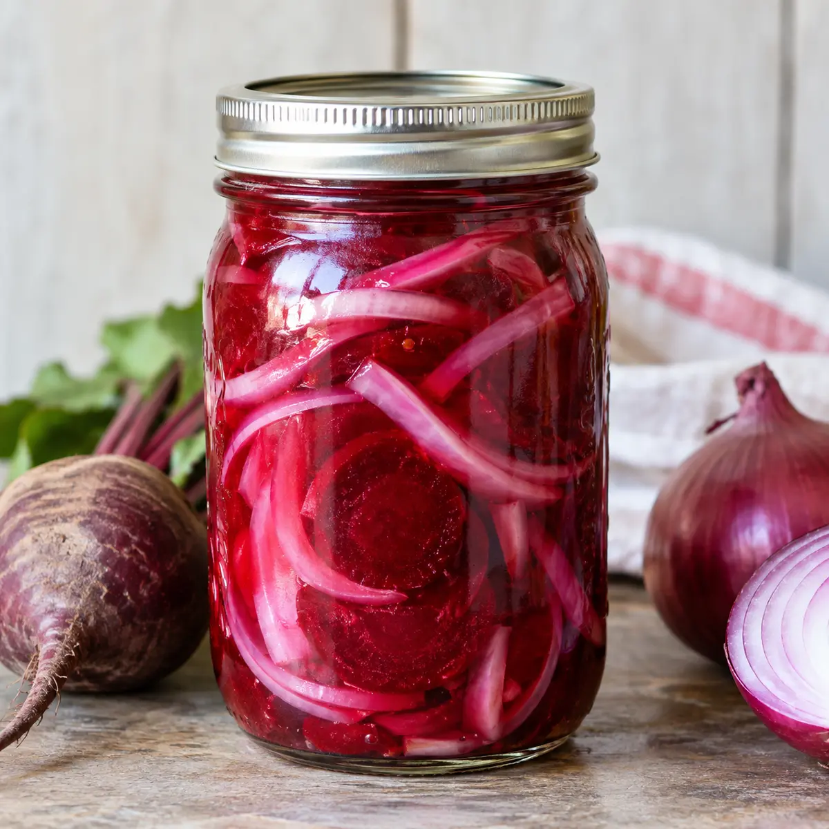 Jar of ruby beet slices and onion strips in magenta brine