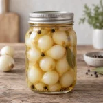 Jar of whole pickled pearl onions in golden brine